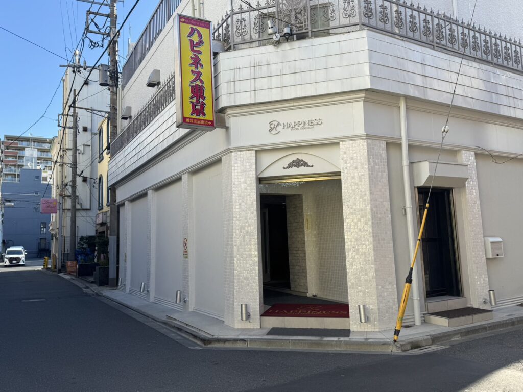 Suggested alt: exterior photo, neon sign and entrance of upscale building at night"